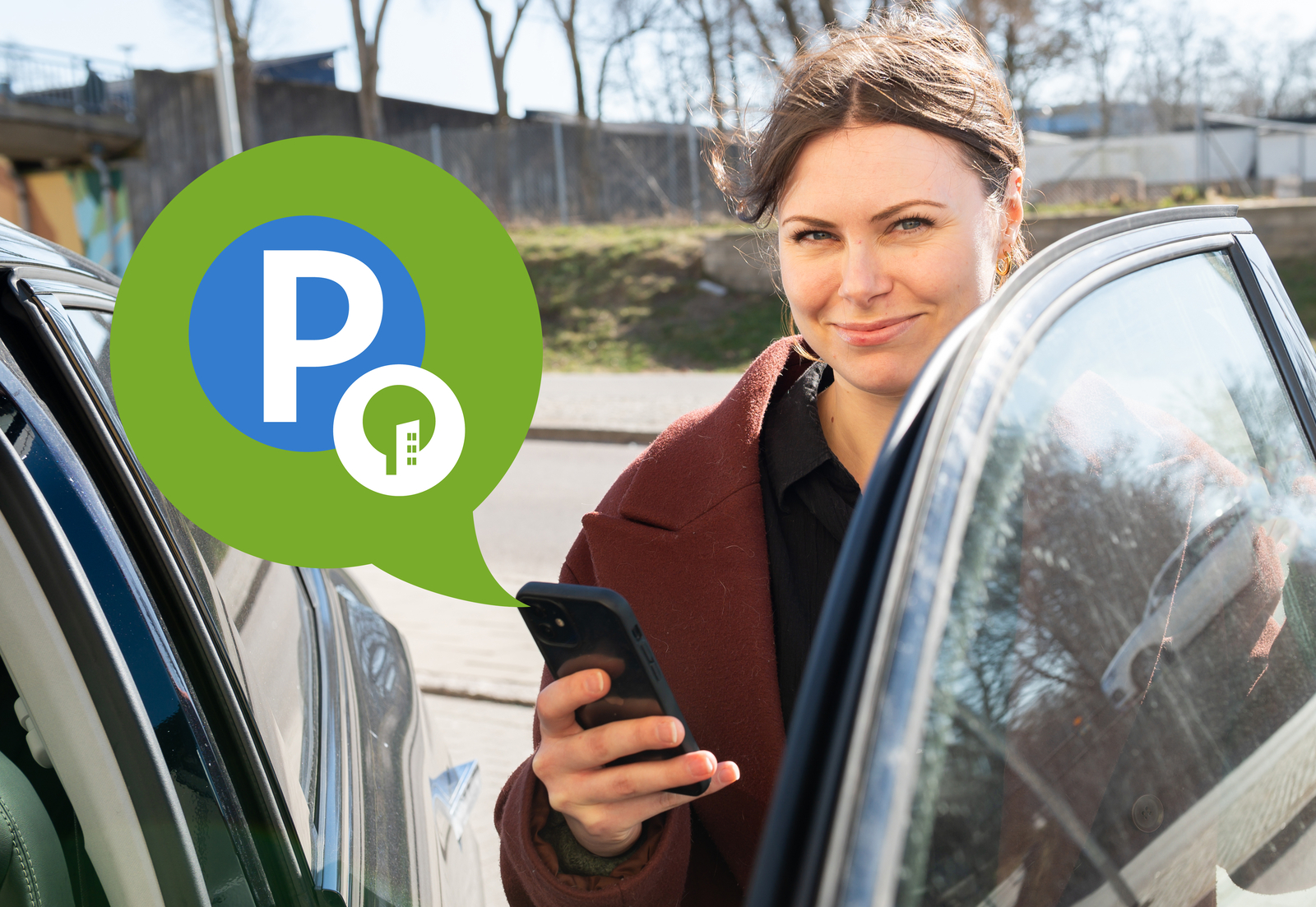 Tjej står med mobil i handen vid en bil